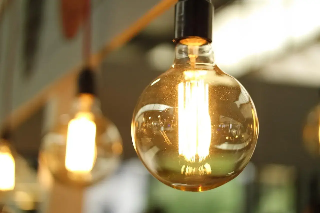 Close-up of a glowing vintage-style light bulb with a blurred background.