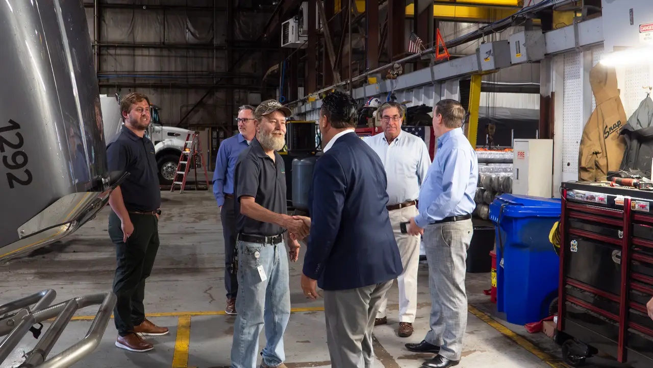 NOCO team members shaking hands and talking inside a NOCO fleet service garage in Buffalo, NY