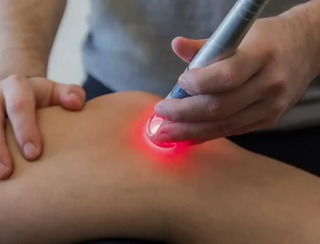 person receiving laser therapy treatment on their knee