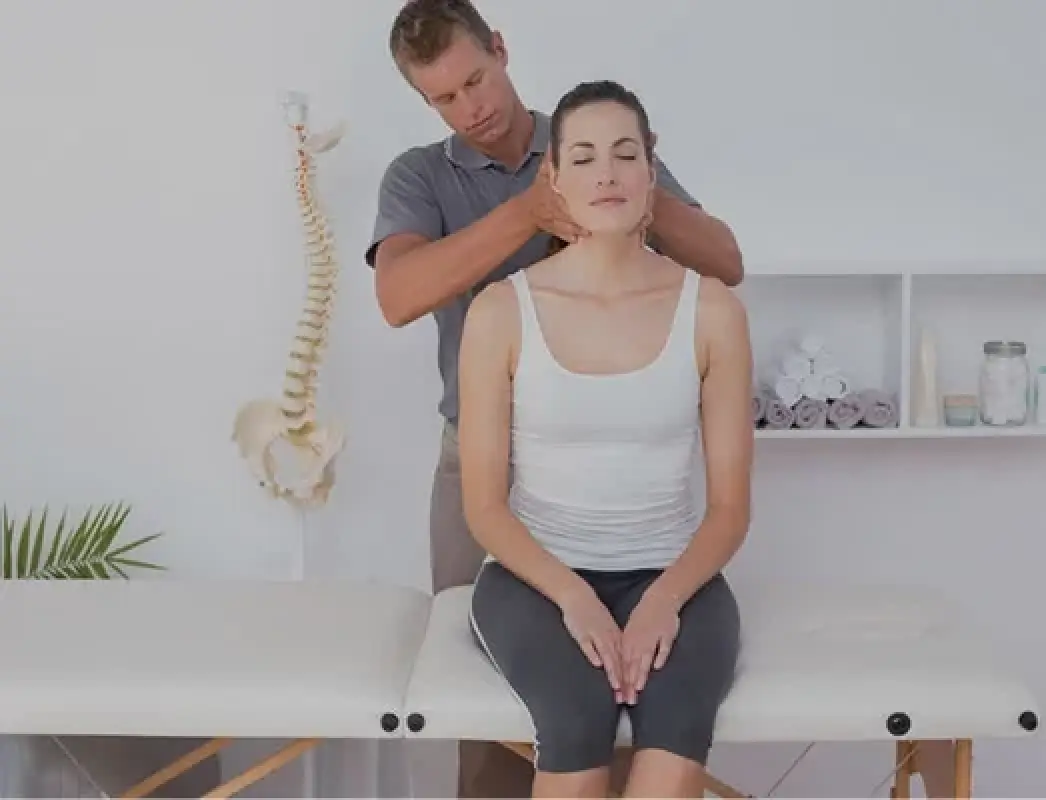 woman receives a neck massage from a man in a therapy room with anatomical decor