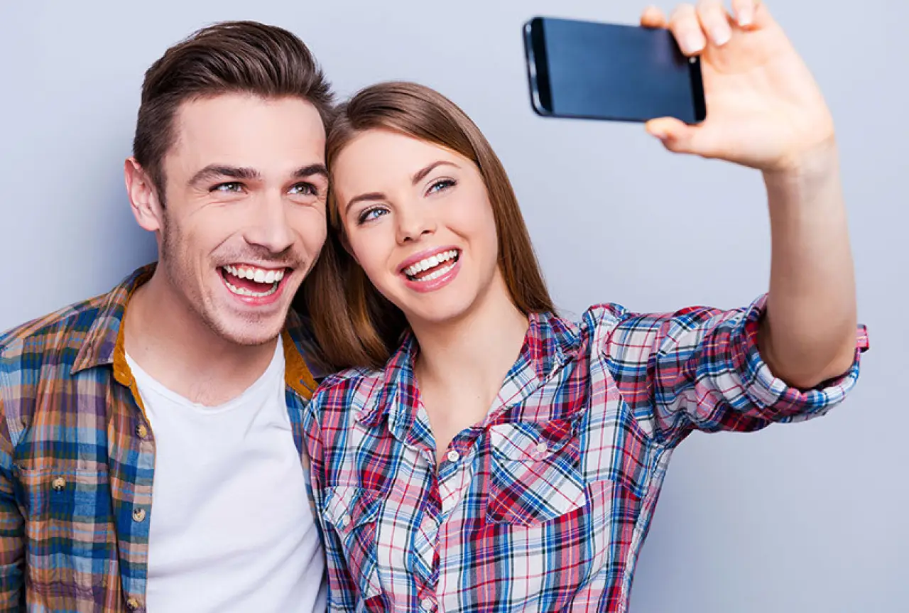 Couple holding up a smartphone and taking a selfie
