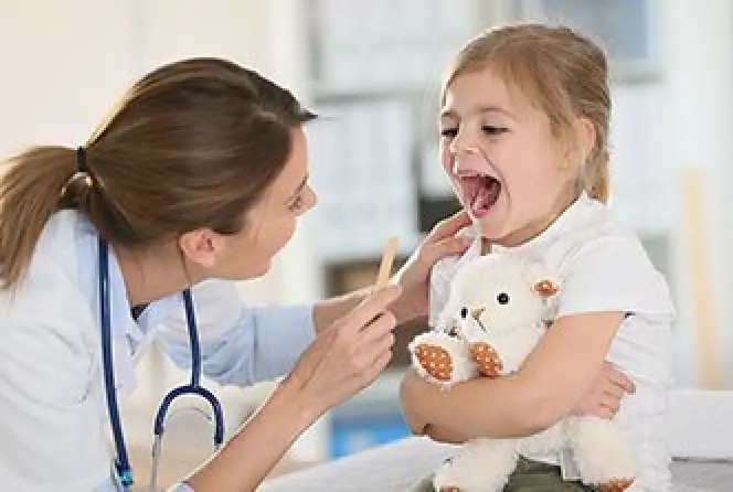 Doctor examines young girl during a community outreach event.