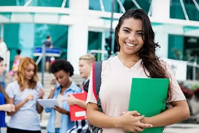 Student holding school folder after receiving scholarship.