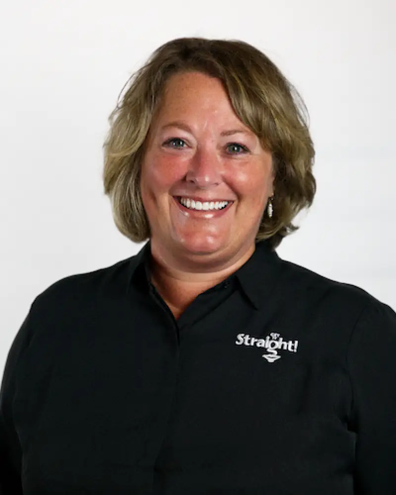 Smiling woman with short hair in a black shirt with Straight logo on a white background.