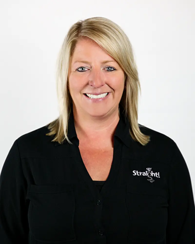 Smiling woman with blonde hair in a black Straighlt shirt against a white background.