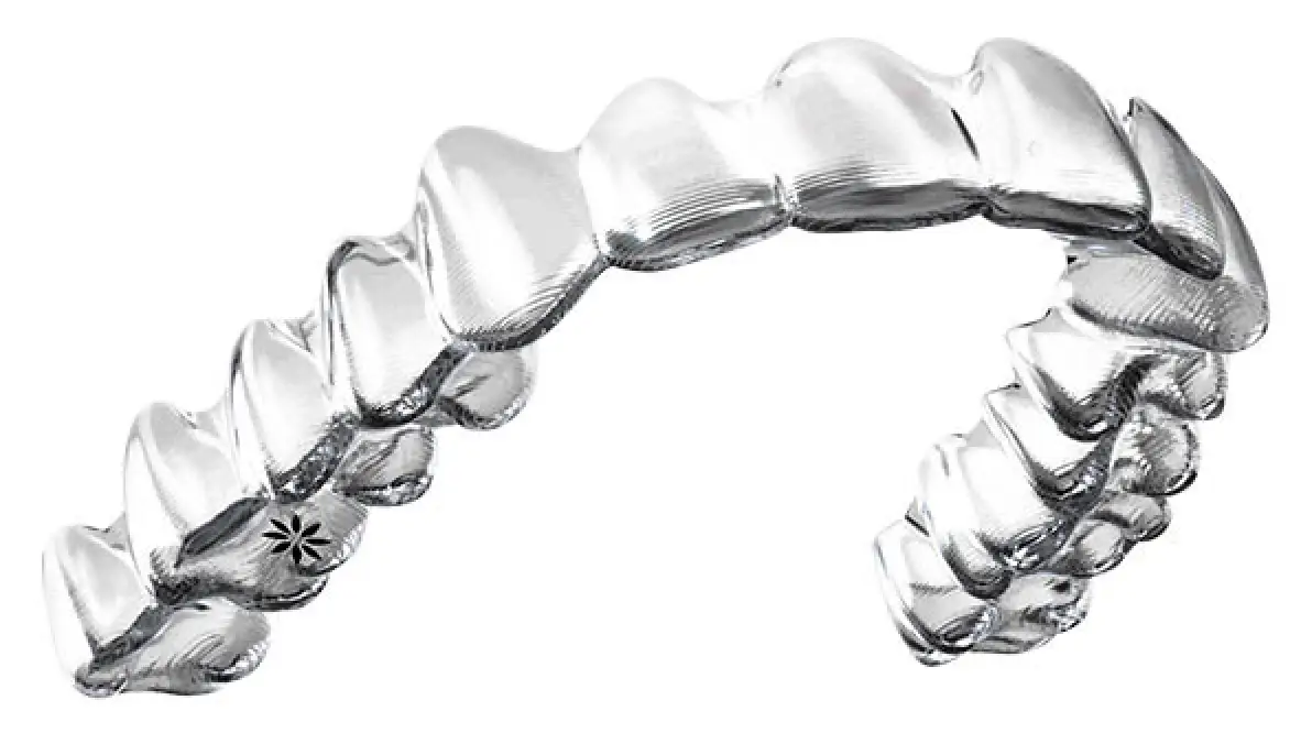 Clear dental aligner resembling a curved row of teeth, used for orthodontic treatment.