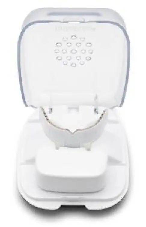 A white dental mouthguard in a ventilated plastic case, viewed from the front.