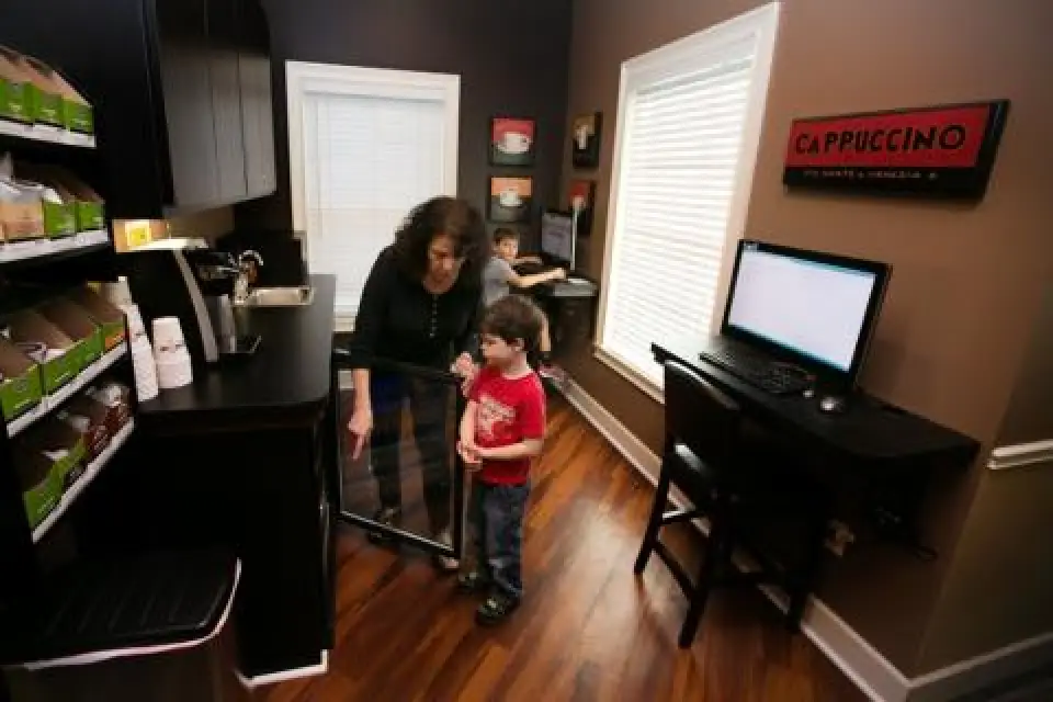 A woman and child looking at a tv