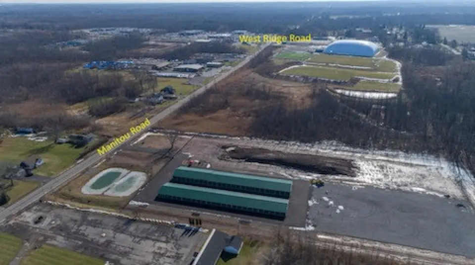 Aerial view of intersecting roads labeled Manitou Road and West Ridge Road, with buildings nearby.