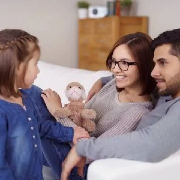 Parents smiling at their young daughter