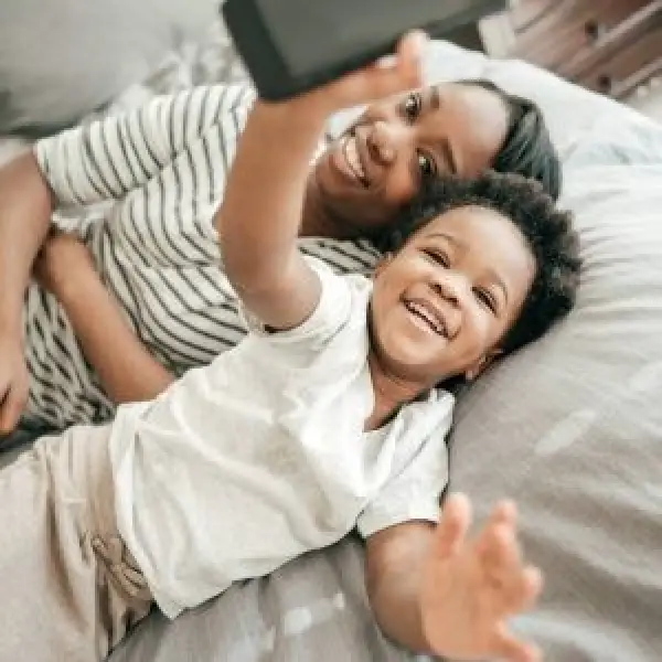 A mom and young son lying on a bed
