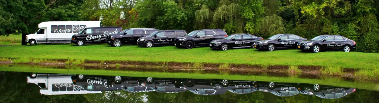 Classy Coach limousine fleet parked beside a lake in Upstate New York.