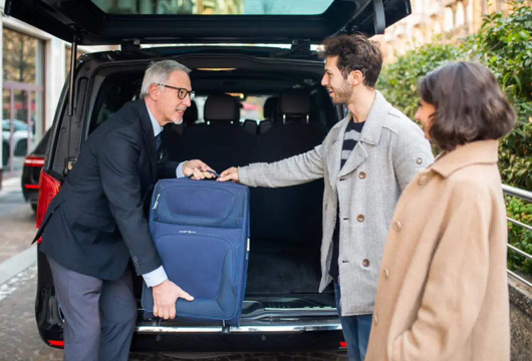 helping someone put luggage in vehicle