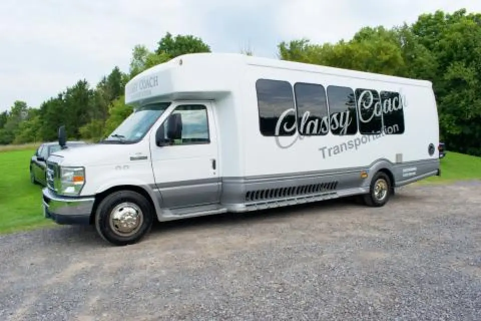 Classy Coach shuttle bus parked on a gravel road.