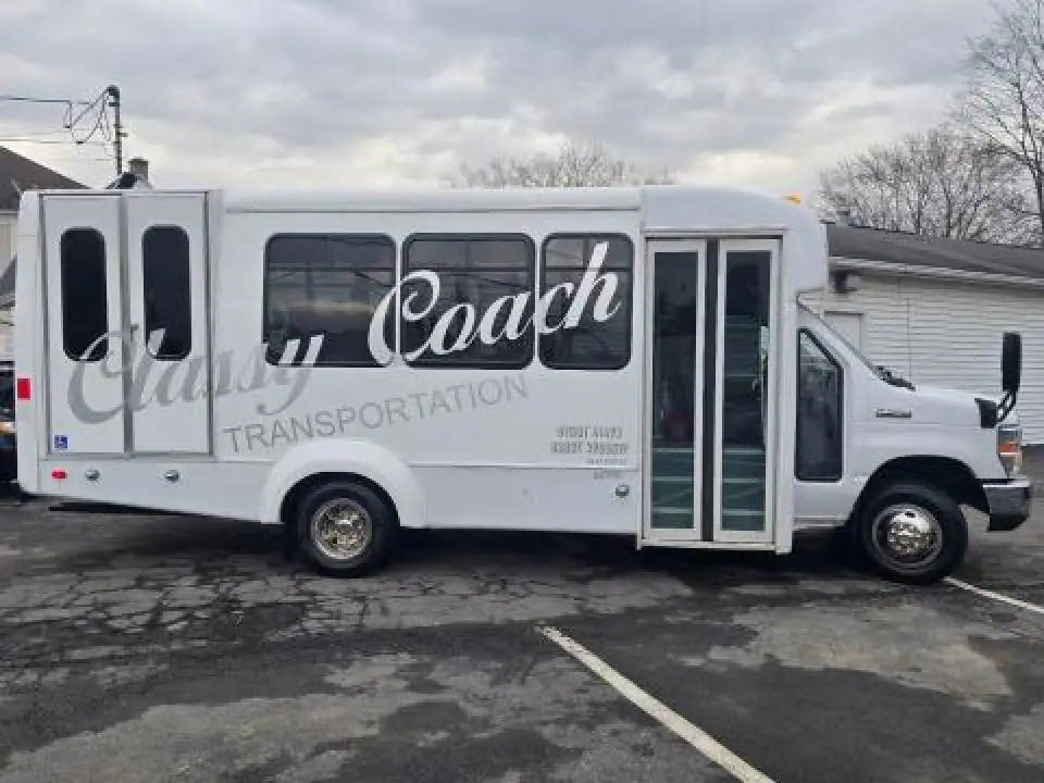 White Classy Coach wheelchair-accessible bus parked outdoors.