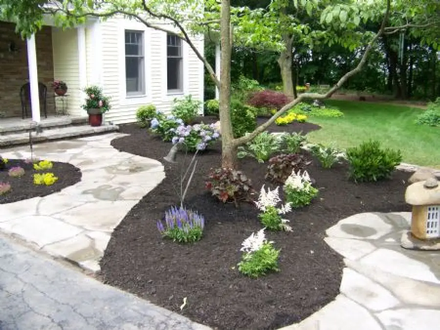 beautiful rochester ny home landscaping with stonework and mulch beds
