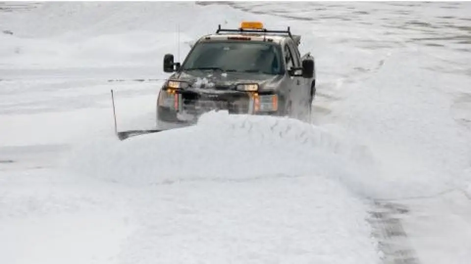 dark colored truck plowing lots of snow