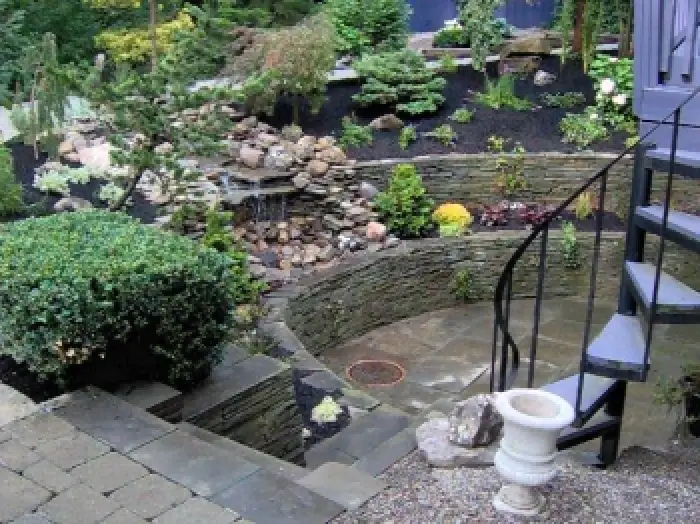 round tiered landscape with circular stairs into home
