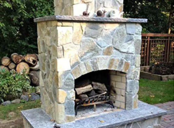 outdoor fireplace with tan and gray stone