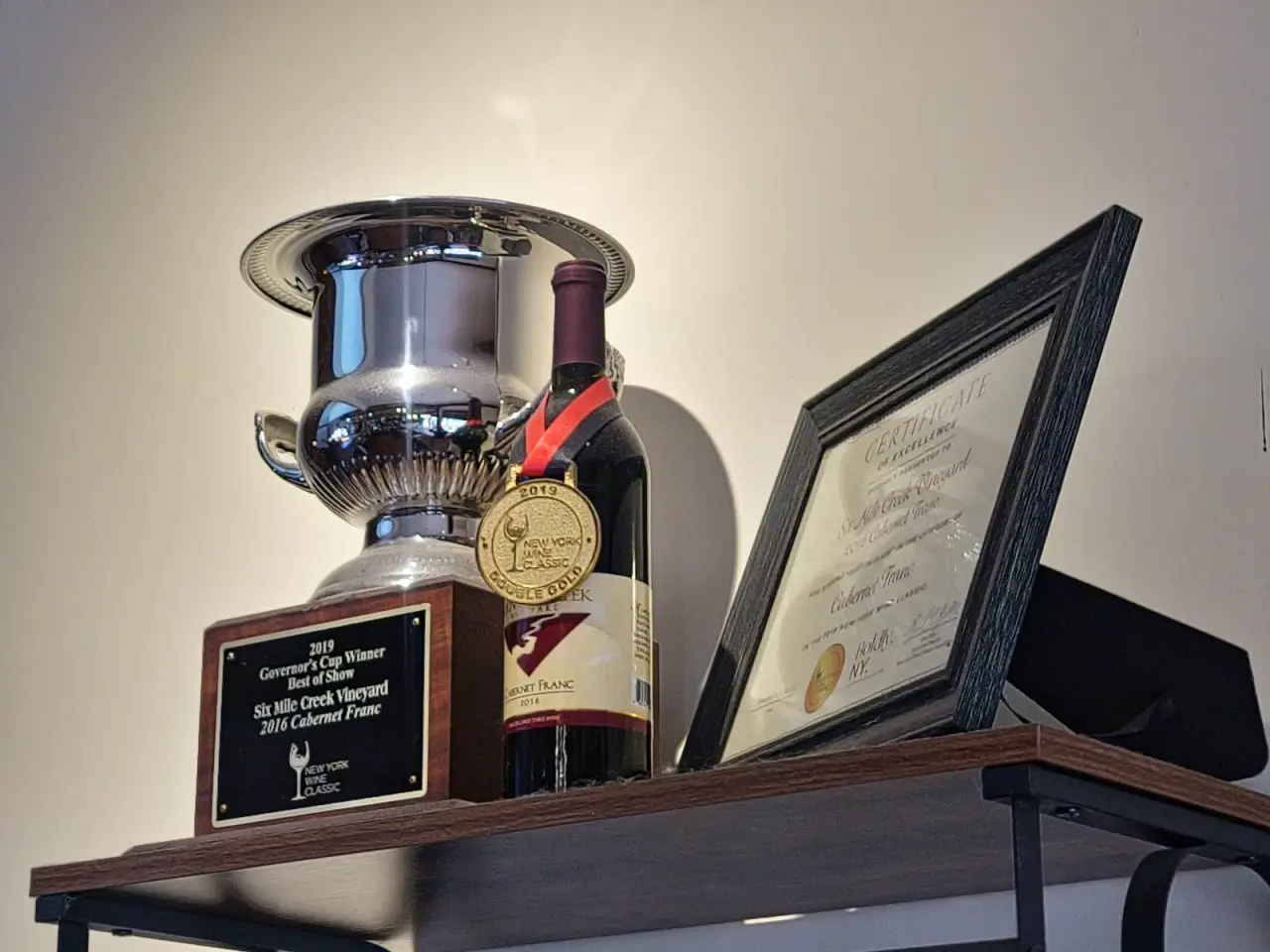 The Governor's Cup trophy and a framed award on a shelf