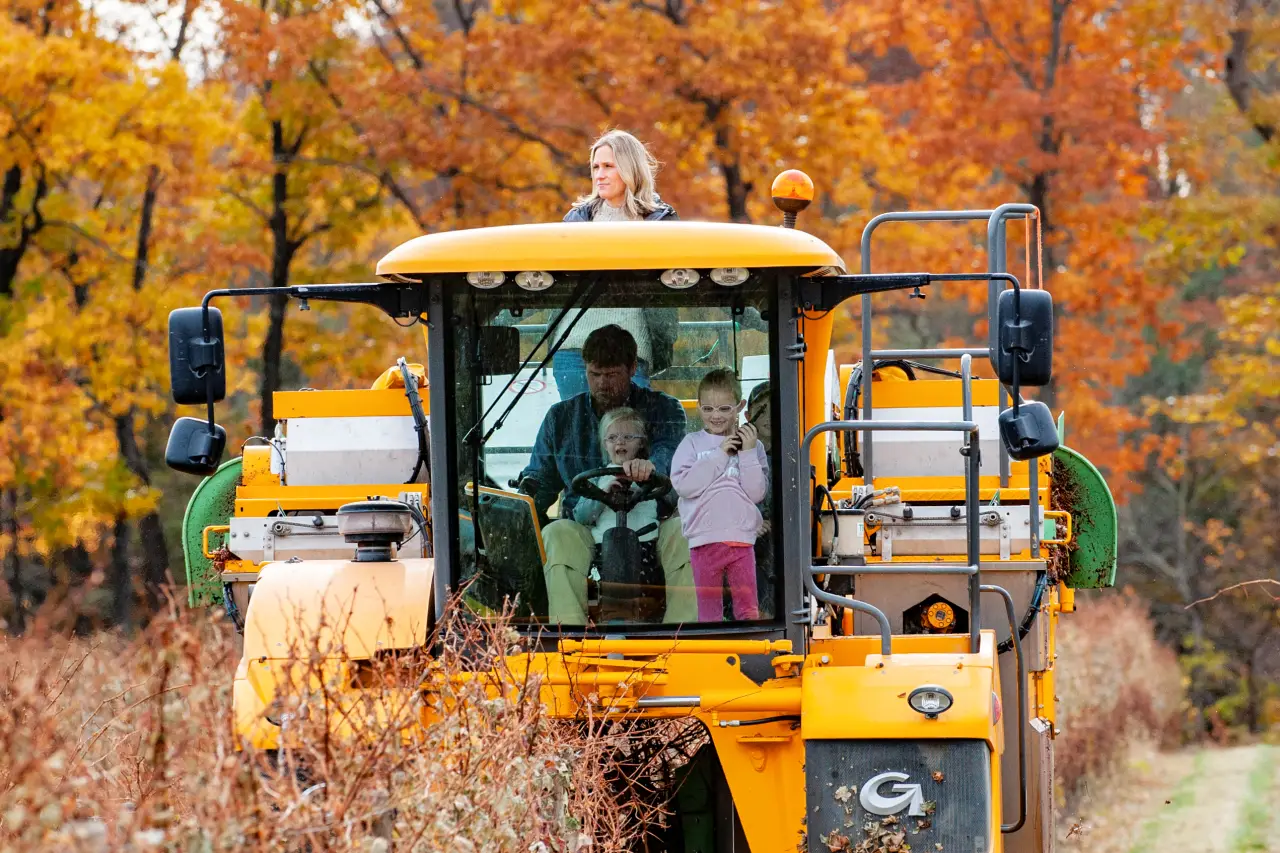 Guests riding the winery's yellow tractor wagon on a fall tour