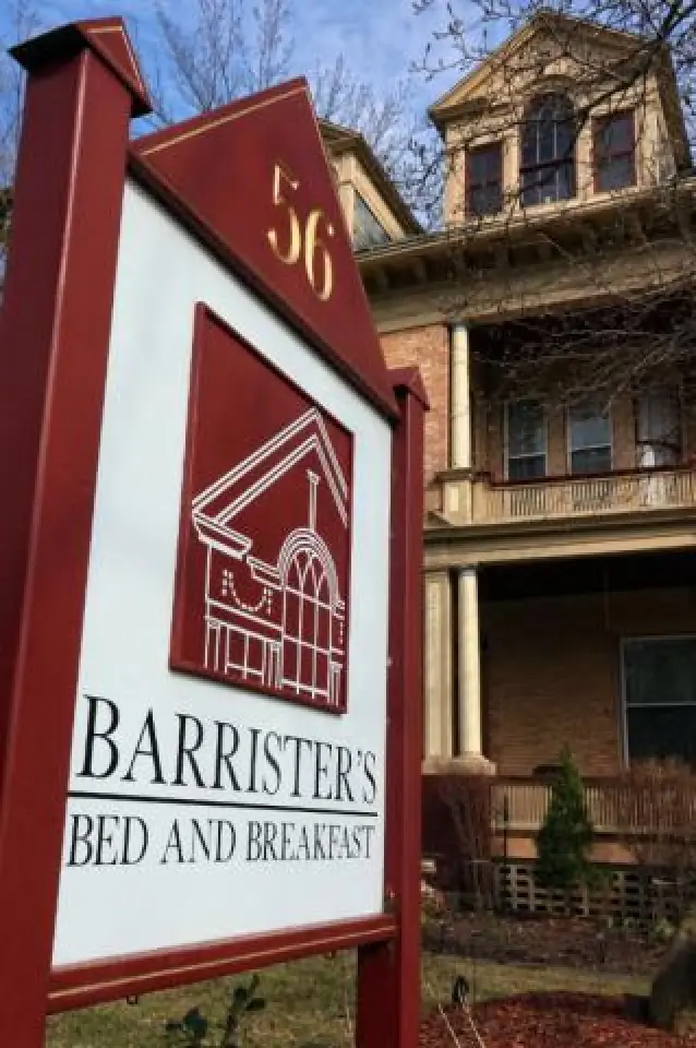 Red sign for Barrister’s Bed and Breakfast in front of a large brick house with columns.