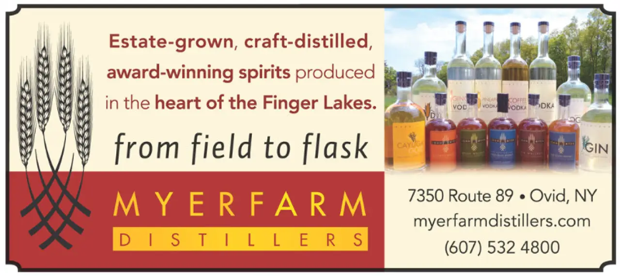 Row of liquor bottles, wheat stalks, and text promoting Myer Farm Distillers in Ovid, NY.