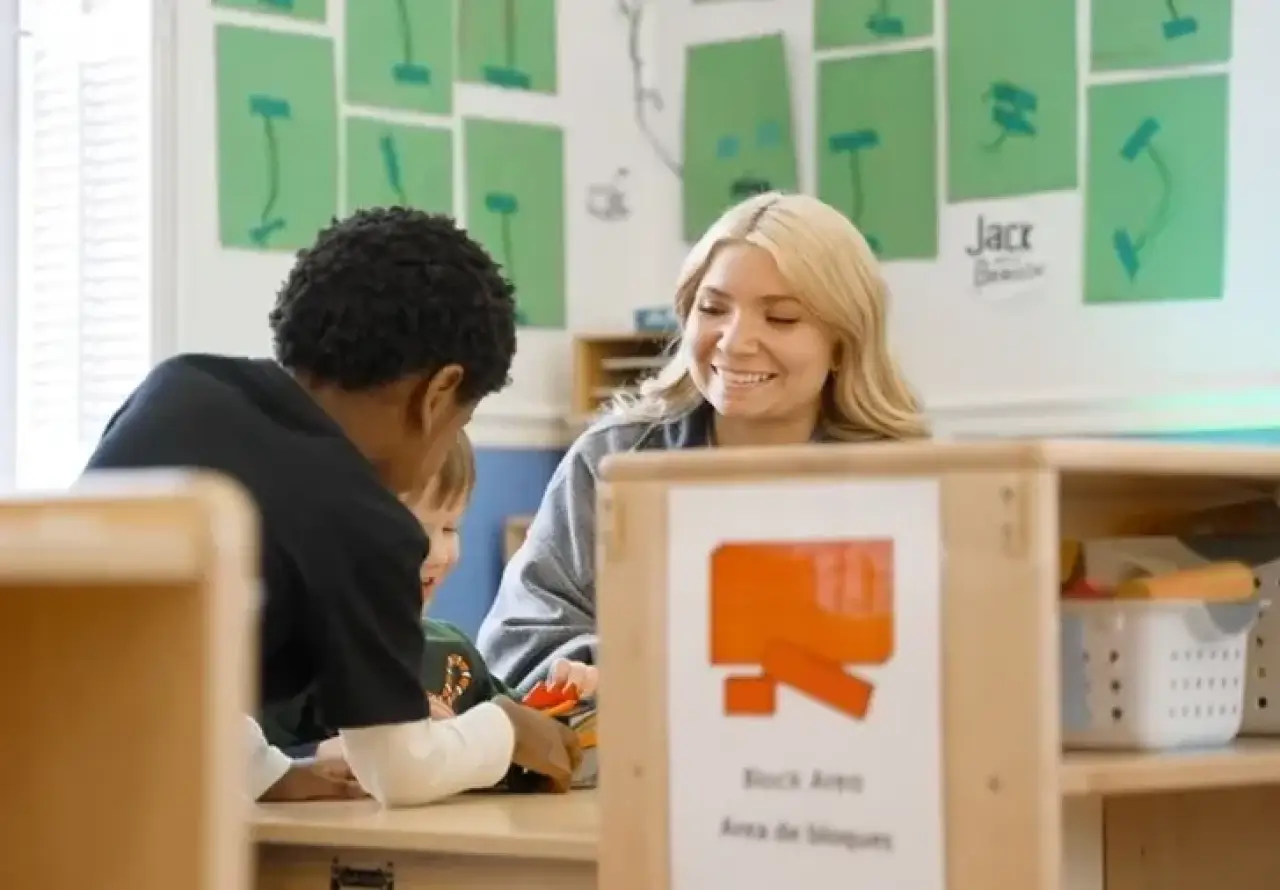 A teacher and a student sitting together at a table.