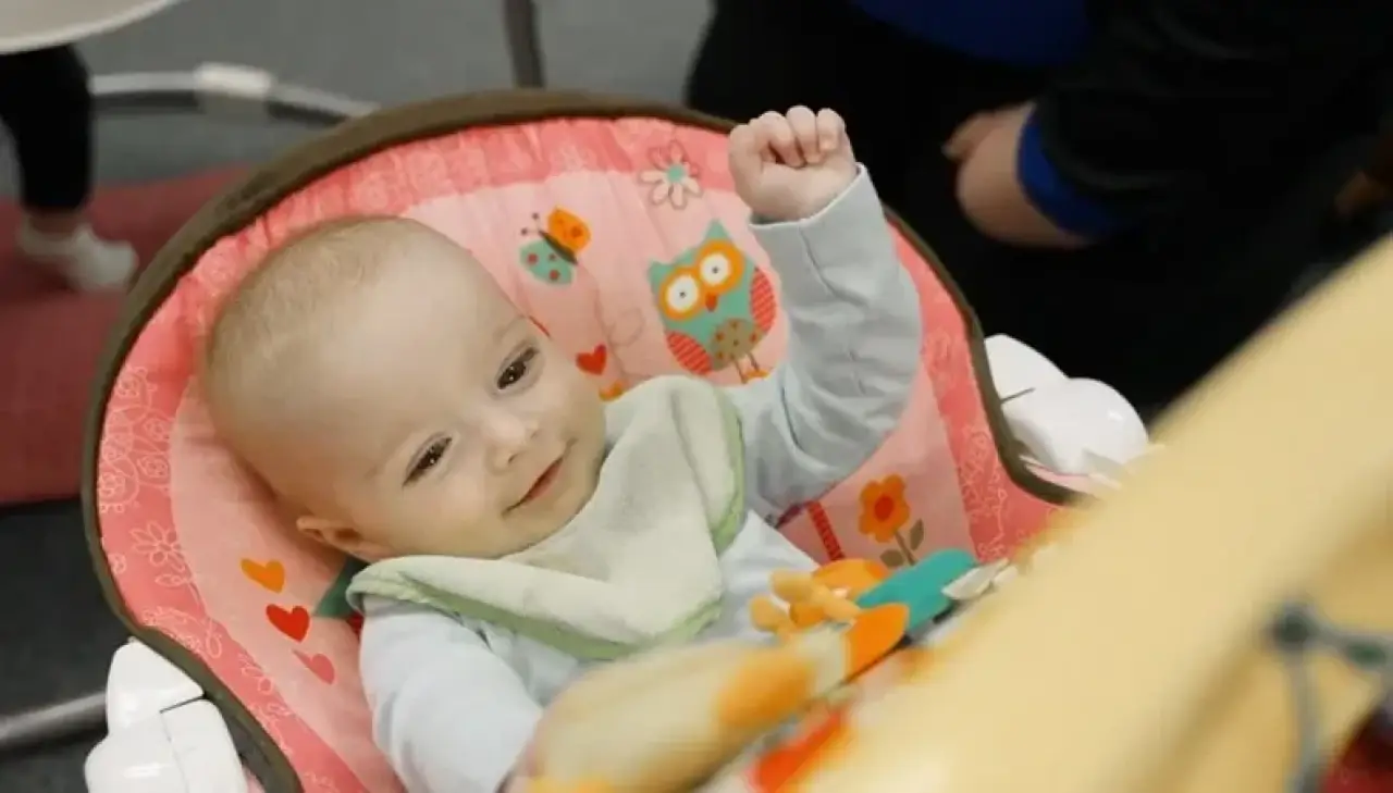 A baby in a pink chair