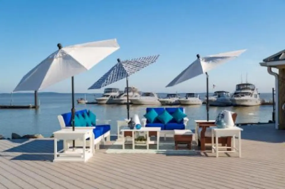 set of white adirondack furniture with blue cushions lakeside