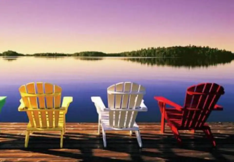 colored adirondack chairs overlooking a lake