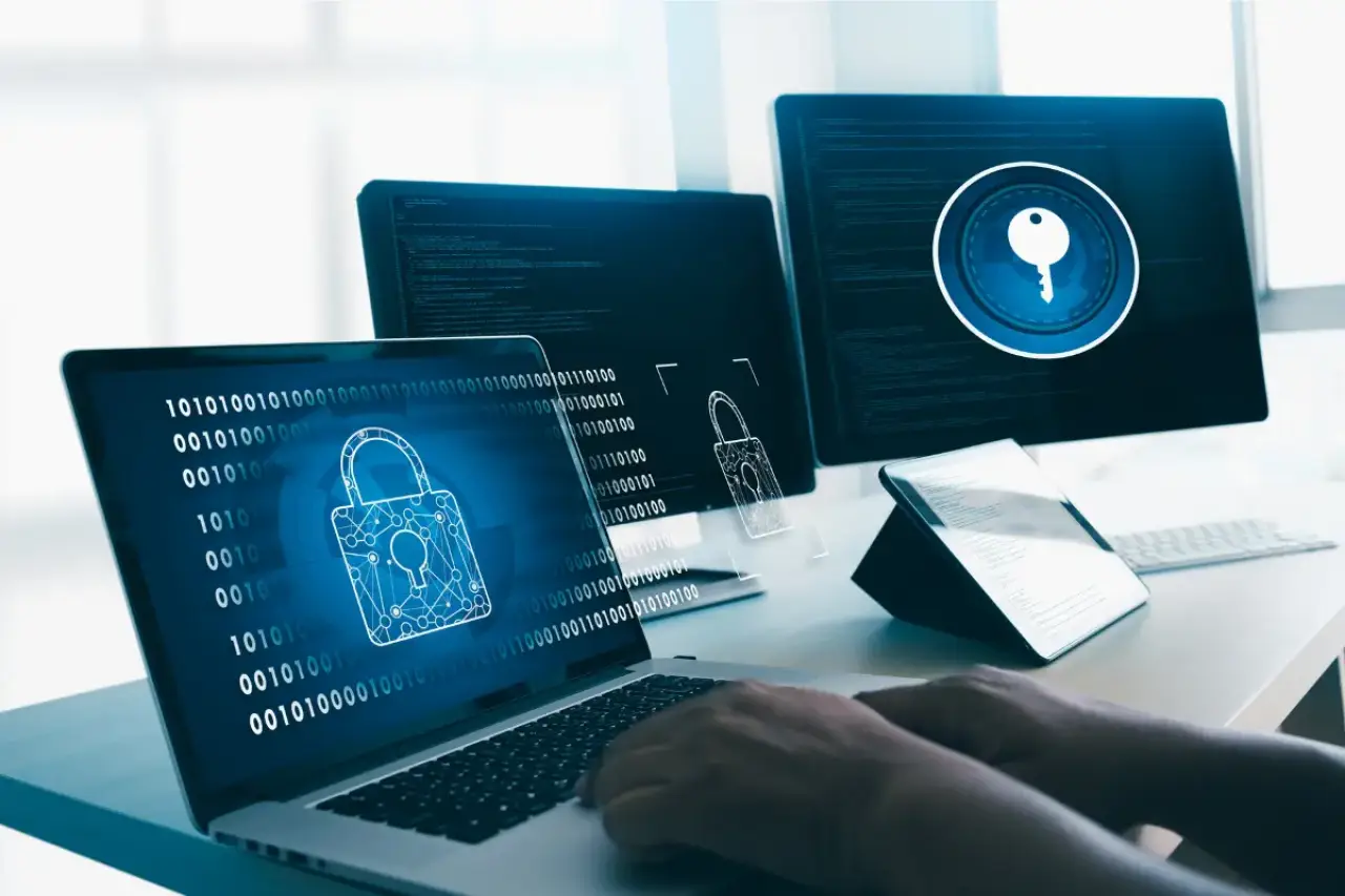person typing with 4 screens showing cybersecurity