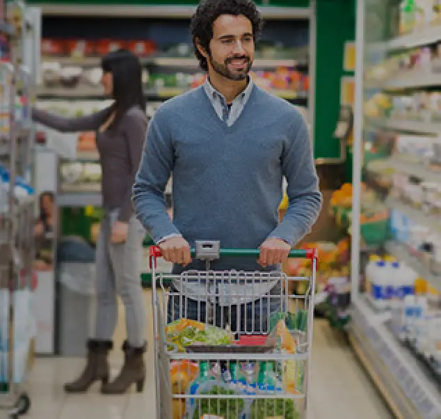 business casual dressed man walks down an aisle with a cart