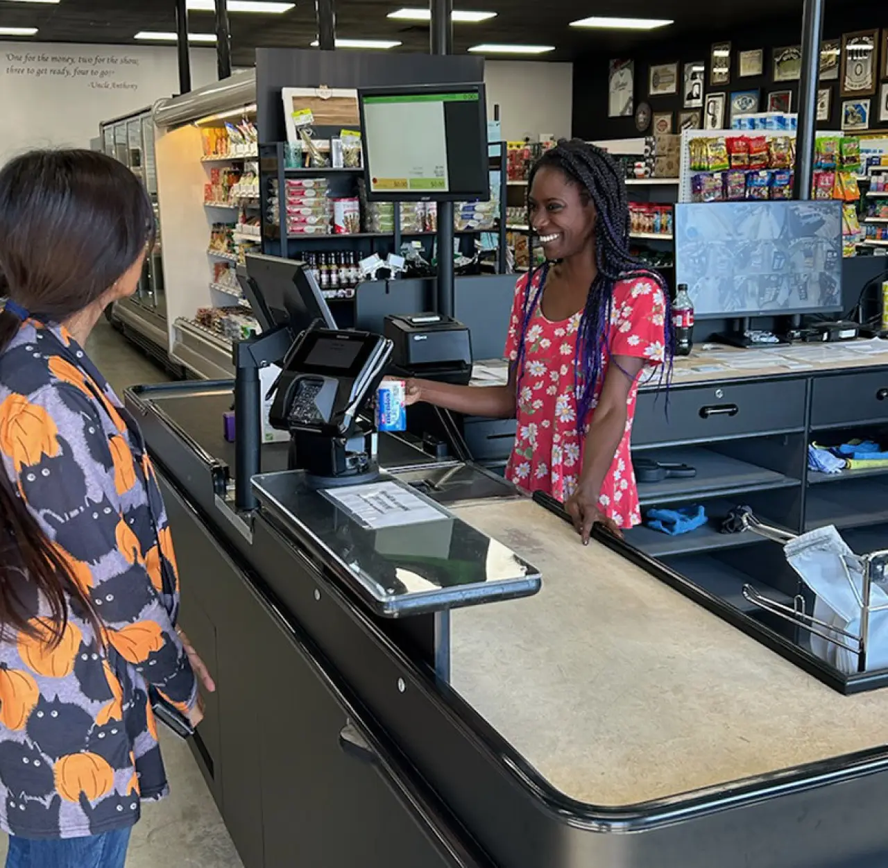 smiling store cashier hands merchandise to customer