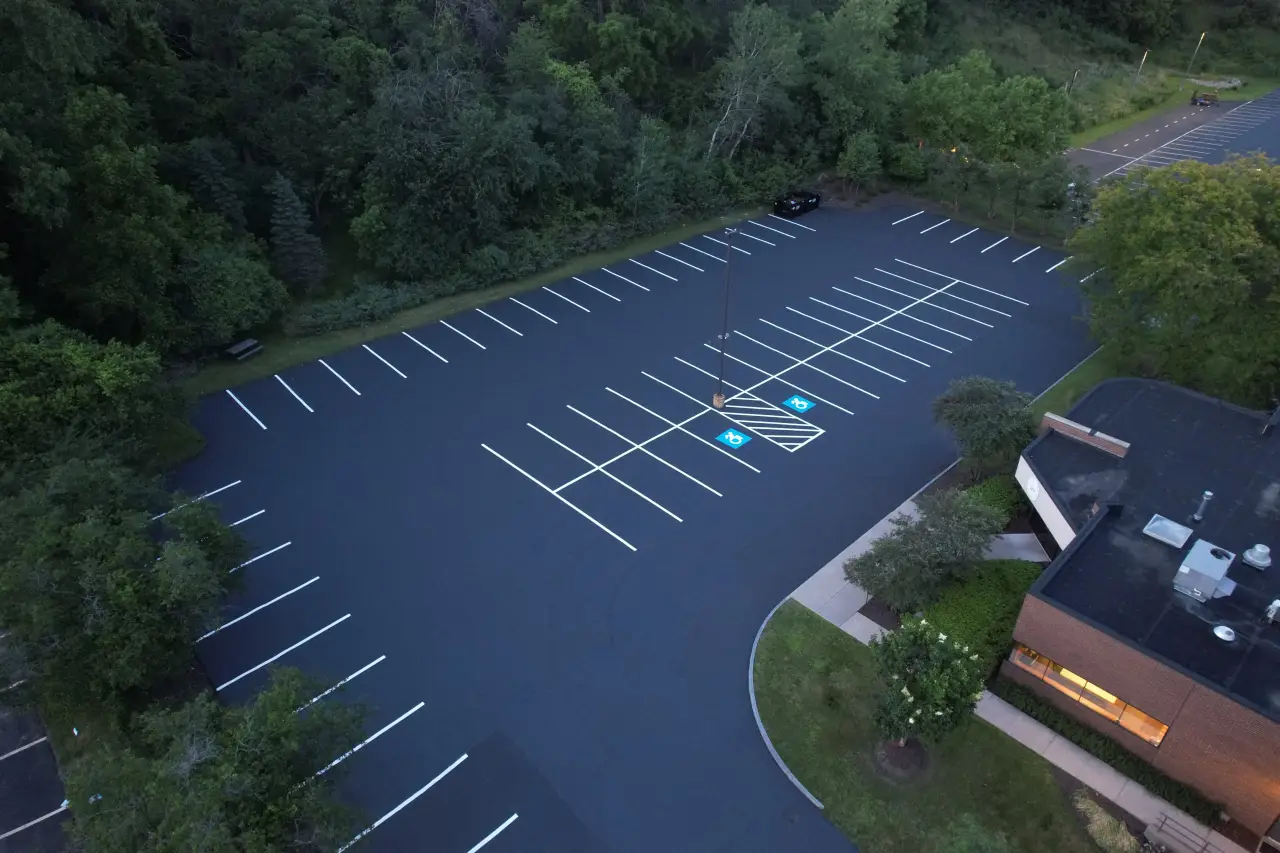 Commercial sealing crew applying asphalt parking lot sealcoating