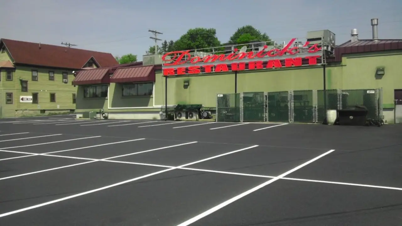 A new parking lot in front of a Dominick's Restaurant storefront sign.