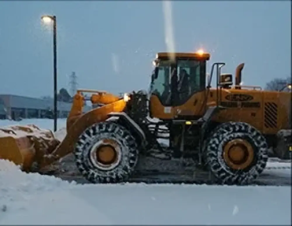 Snow plowing equipment clearing a commercial lot
