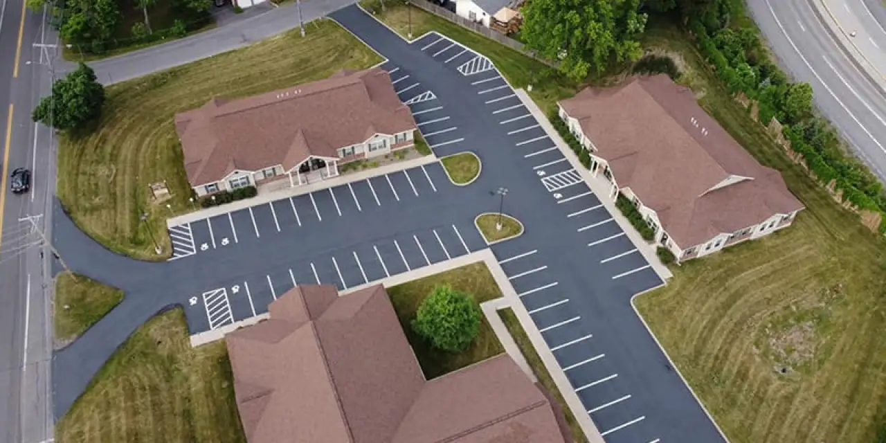Aerial view of three buildings and a freshly paved parking lot