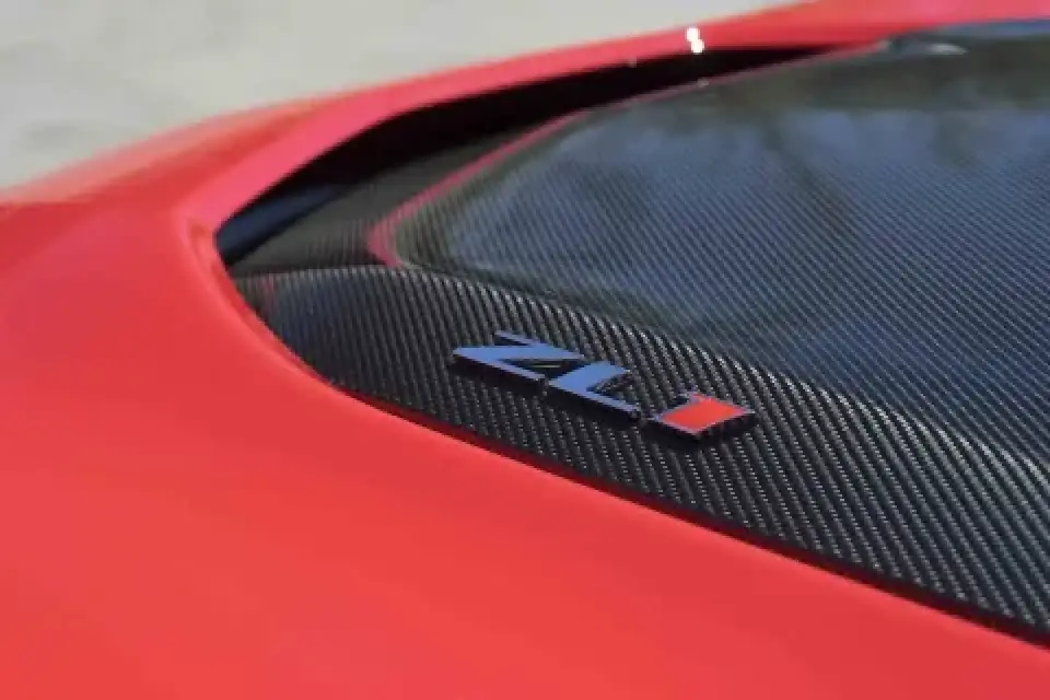Close-up of a red car with a carbon fiber panel and a ZL1 badge.