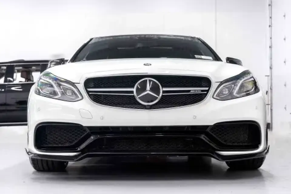 Front view of a white Mercedes-Benz car in a bright, modern indoor setting.