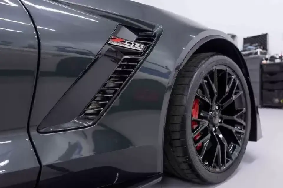Close-up of a dark gray sports cars front wheel and Z06 badge, with red brake calipers.