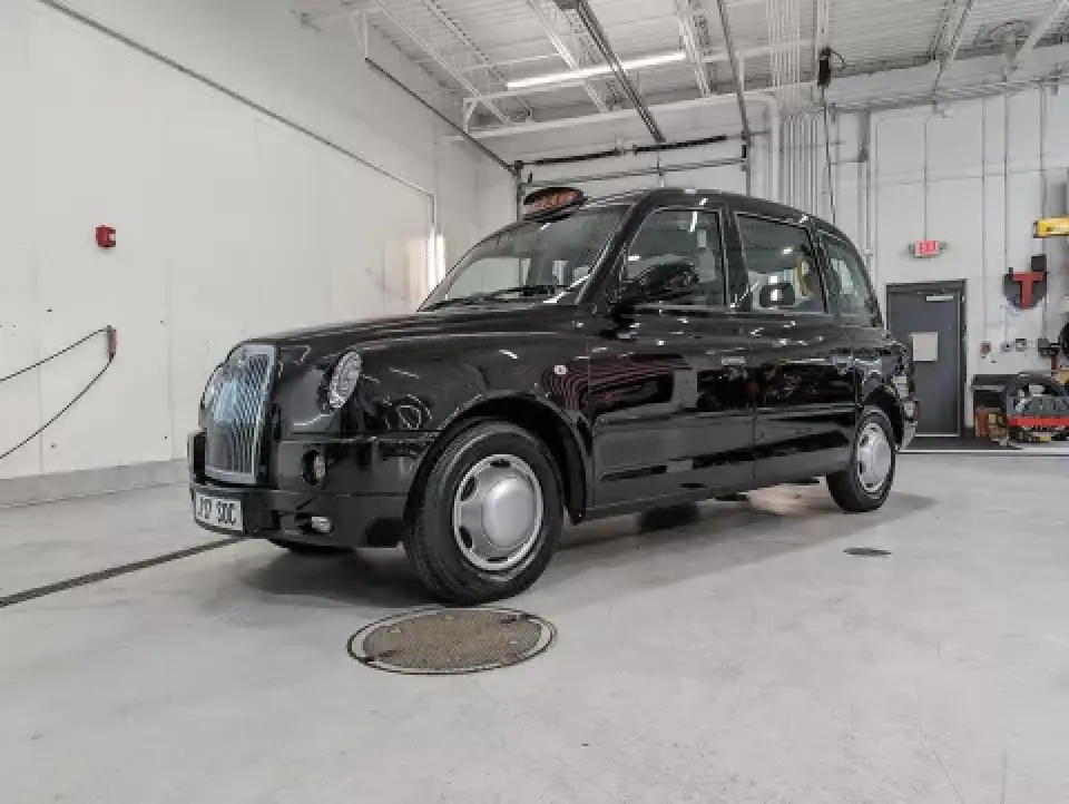classic London taxi parked inside bright garage workshop