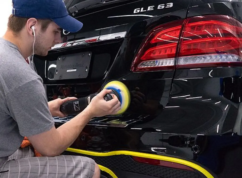 man detailing exterior of black car