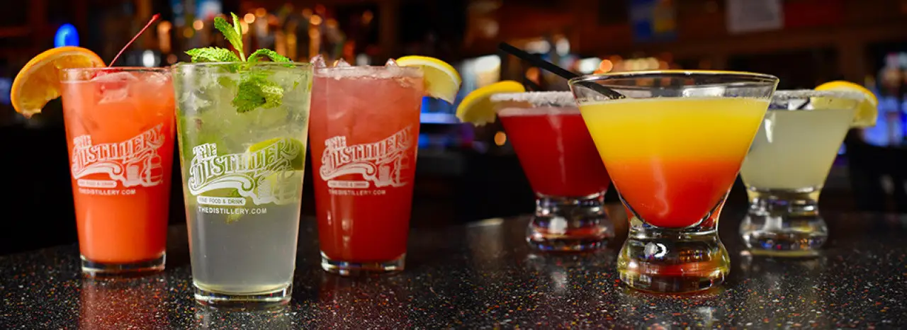 Signature cocktails lined up on a bar at The Distillery