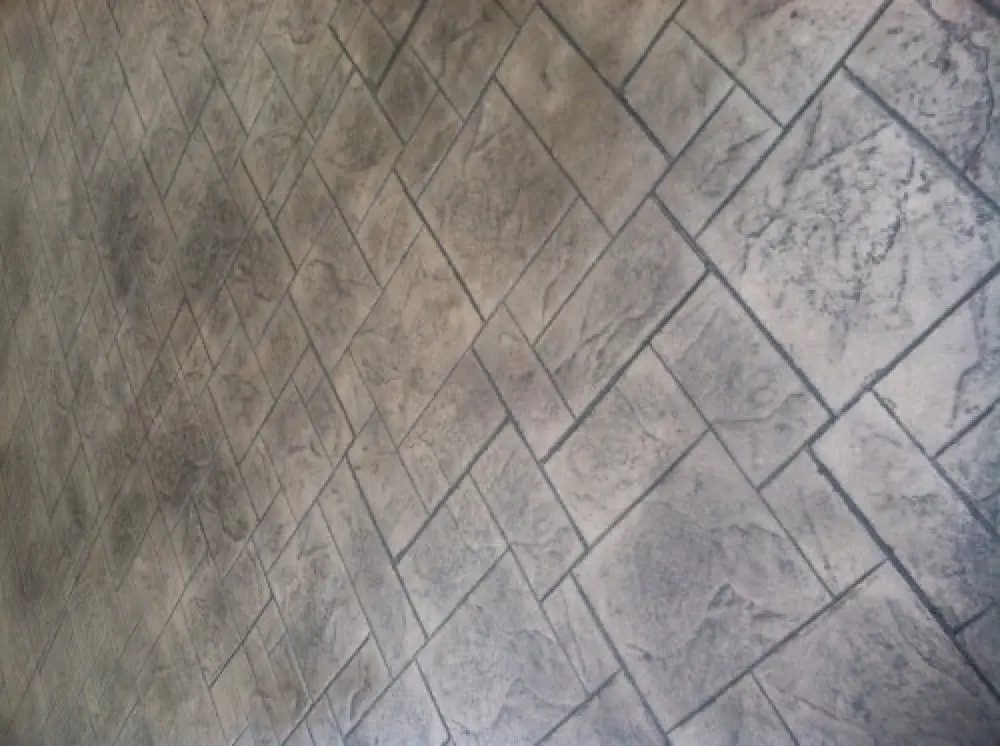 Close-up of a textured, patterned stone tile floor with a geometric, diagonal design.
