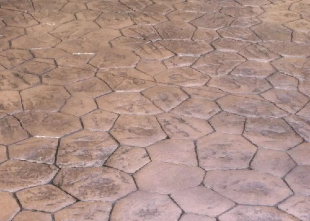 Brown stamped concrete floor with irregular hexagonal and pentagonal patterns.