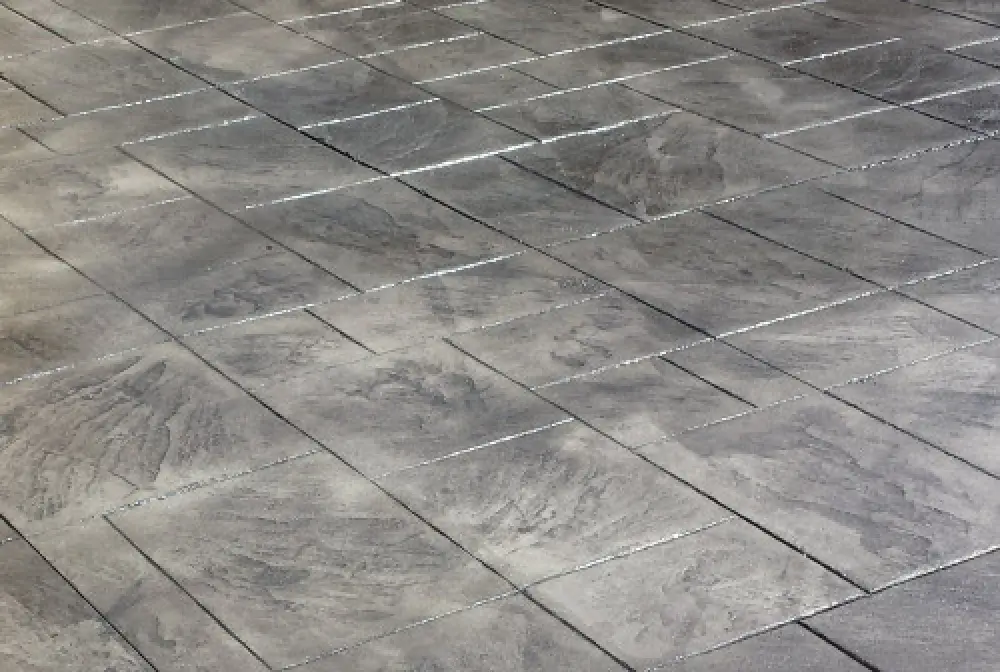 Gray rectangular stone tiles arranged in a staggered pattern on a flat surface.