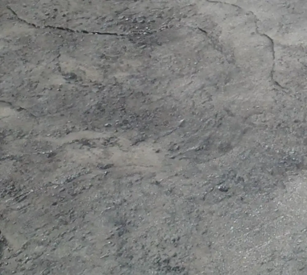 Rough, cracked gray concrete surface with uneven texture and visible lines and patches.