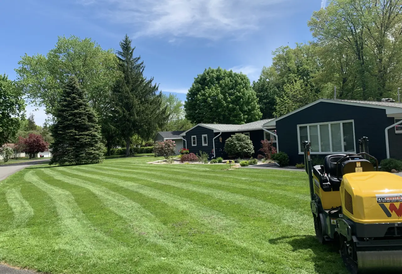 A freshly mowed lawn in front of a dark blue house.