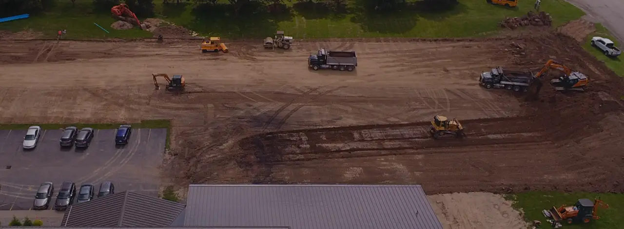 Shamrock Paving excavator digging on a commercial site in Victor NY